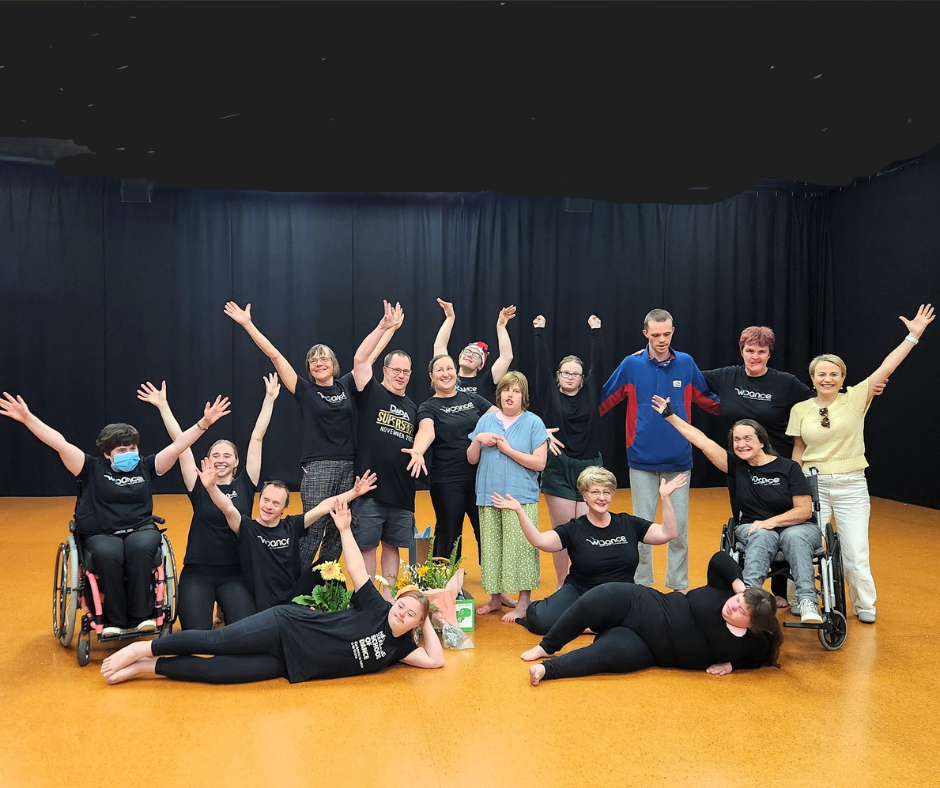 A large group of WIDancers strike a pose in the studio with Paula Tesoriero 